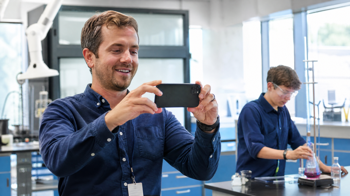  Professor e aluno gravando vídeo autêntico em laboratório de ciências para campanha escolar. 